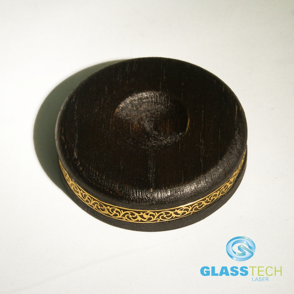 Černý stojánek s ozdobným páskem zlaté barvy 